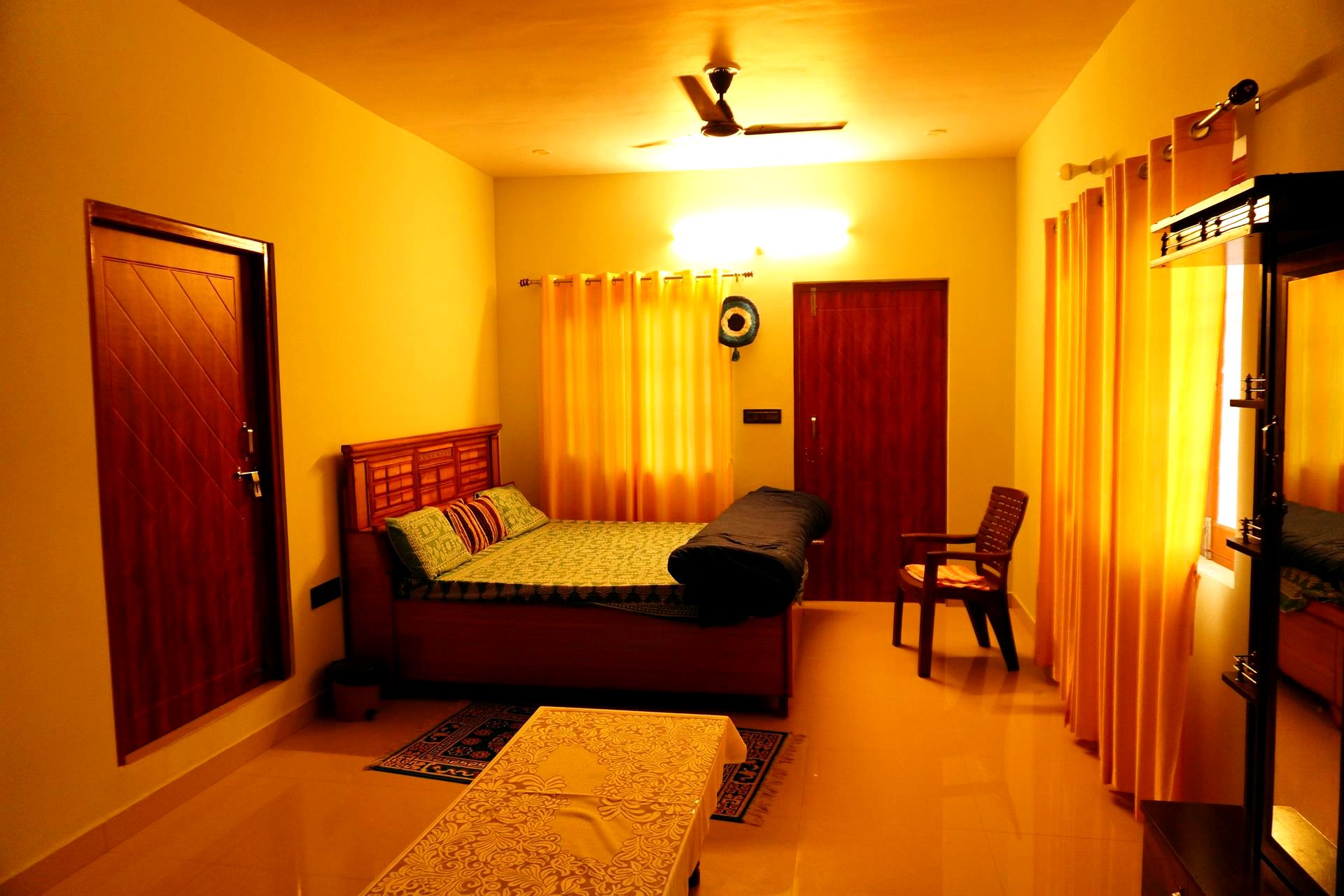 Bright bedroom with ceiling fan and green bedspread